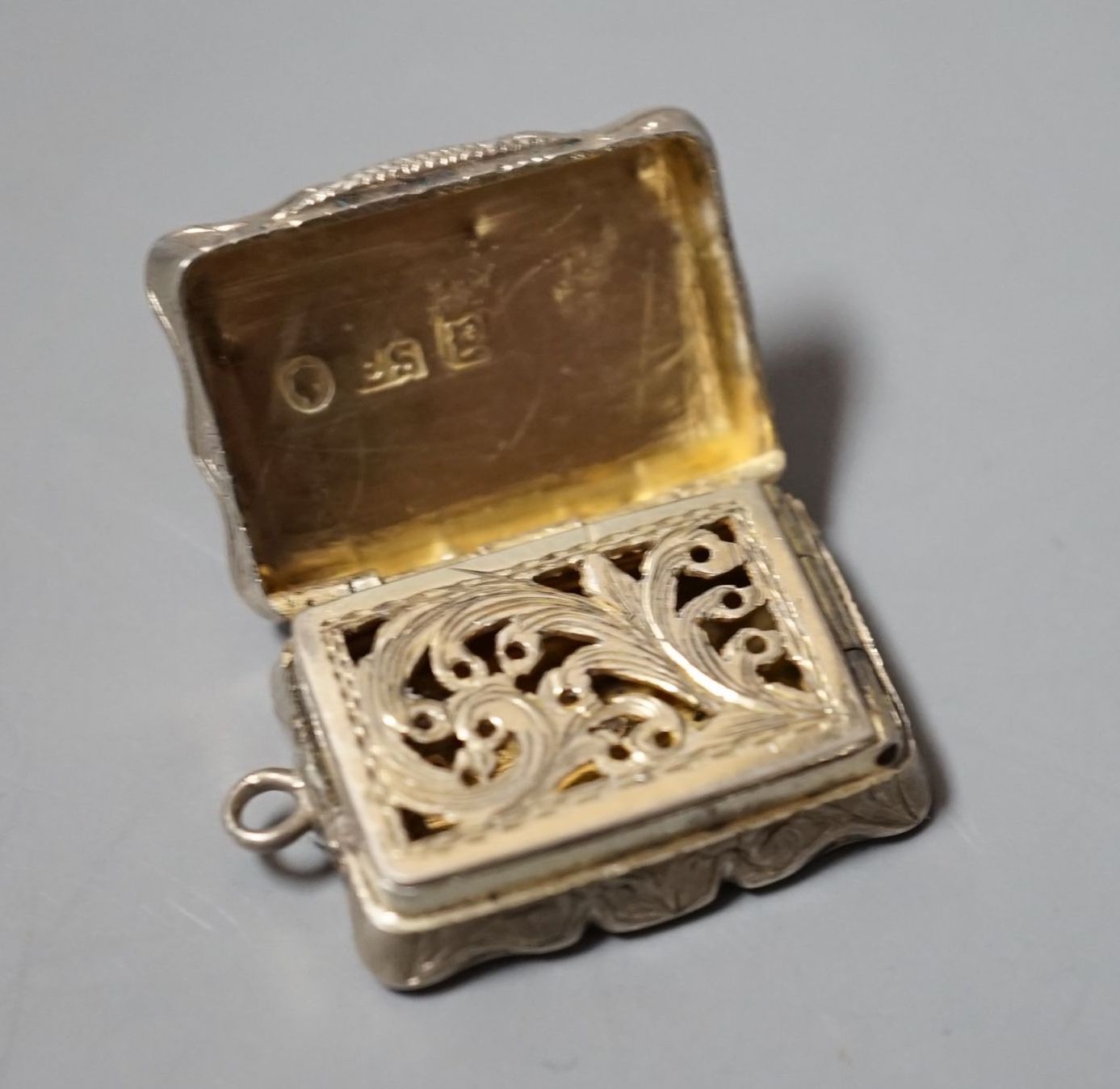 A Victorian engraved silver shaped rectangular vinaigrette, Edward Smith, Birmingham, 1847, 27mm.